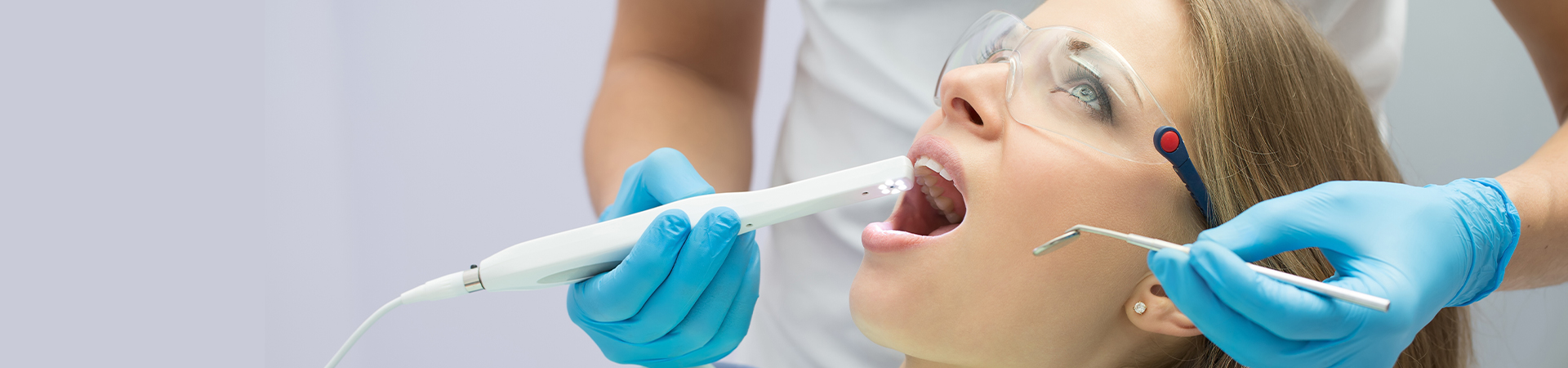 A dental professional demonstrating TMJ treatment techniques to a patient in a well-lit dental clinic at New Smile Dentistry.