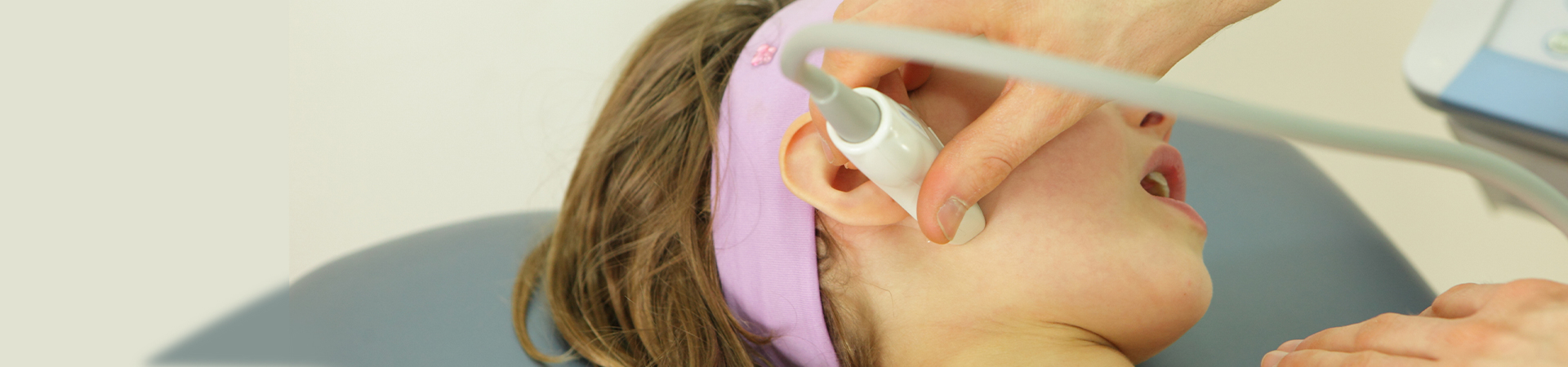 A dental professional demonstrating TMJ treatment techniques to a patient in a well-lit dental clinic at New Smile Dentistry.